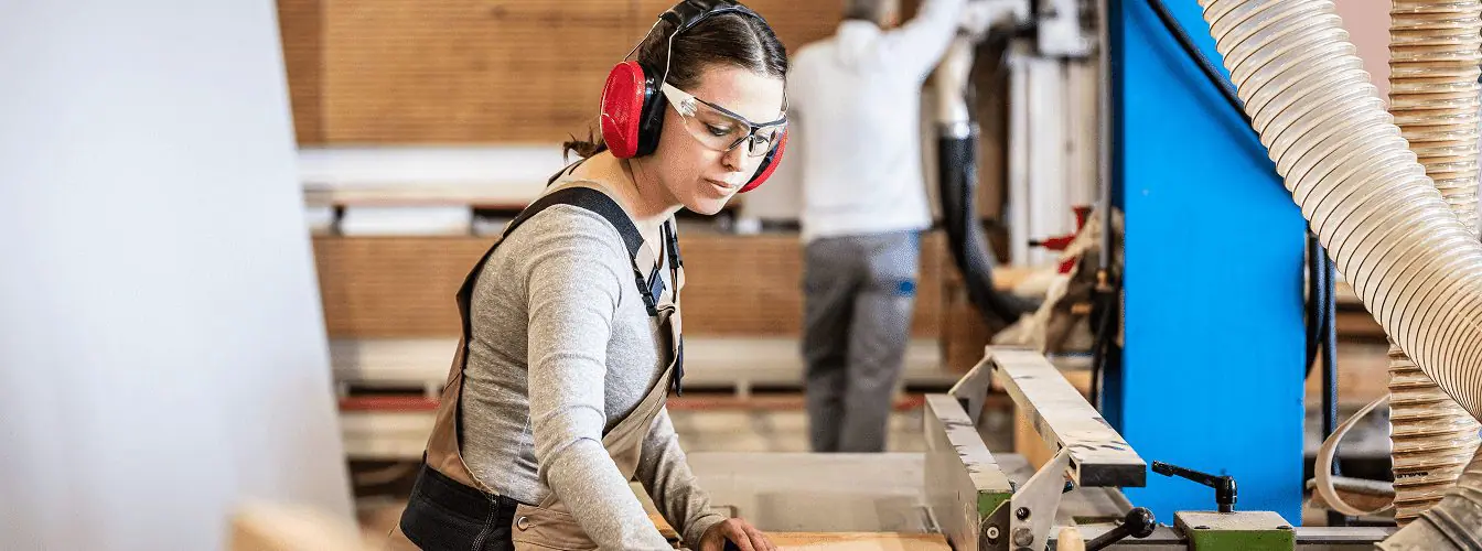 Women working in workshop with protective gear.